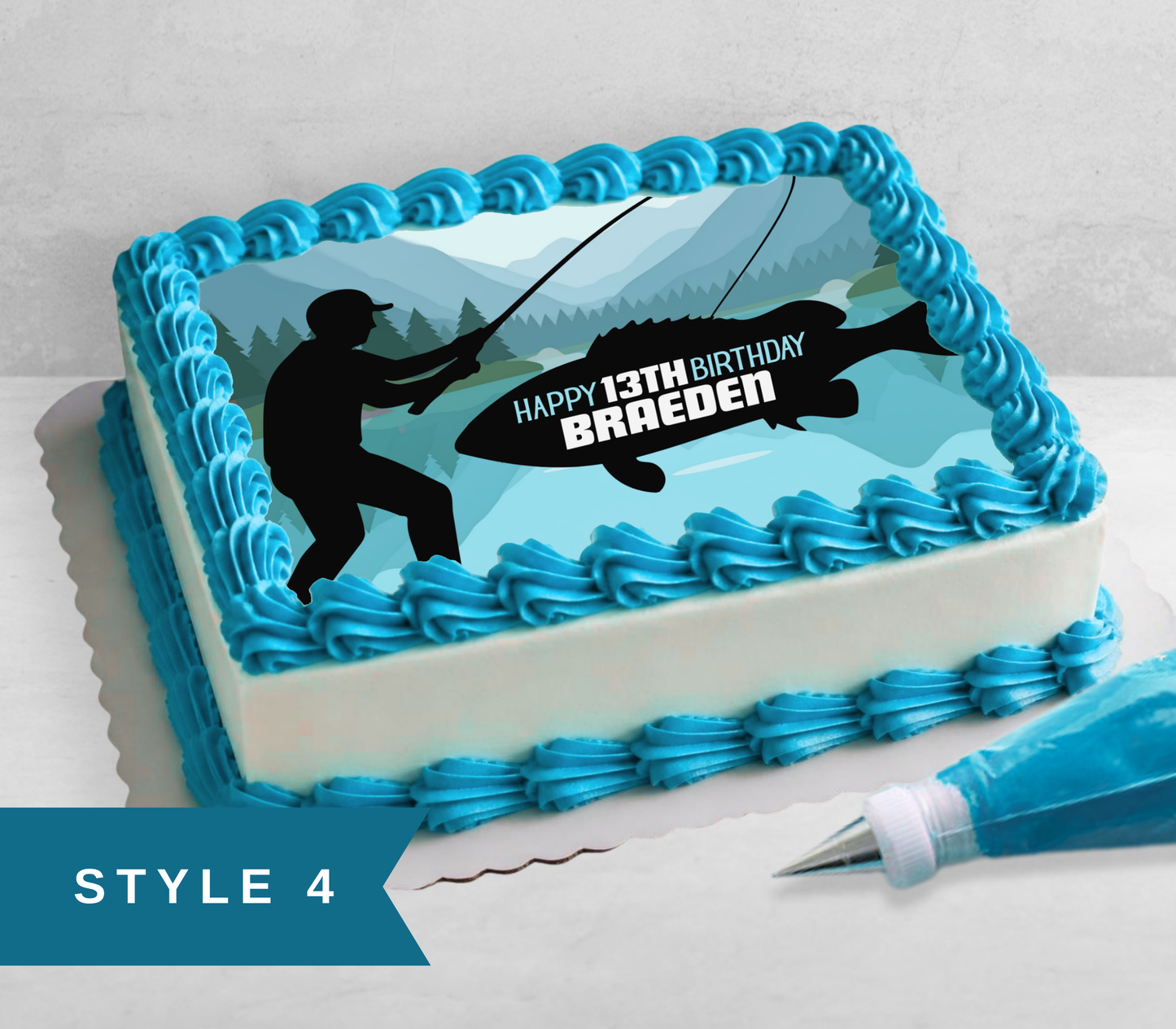 A rectangular birthday cake decorated with bright blue piped frosting borders and a fishing-themed printed top design showing a black silhouette of a fisherman, a large fish, mountains, and the text 'HAPPY 13TH BIRTHDAY BRAEDEN'. A piping bag is placed beside the cake on a light surface.