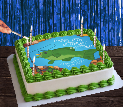 A rectangular birthday cake decorated with green piped frosting borders and a blue fishing-themed topper showing a green fish and the text 'HAPPY 13TH BIRTHDAY BRAEDEN.' A hand is holding a lit candle on the top left, with several more candles on the cake against a blue tinsel backdrop.