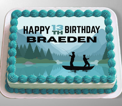 A rectangular cake with turquoise piped frosting borders and a printed top design showing a lake, mountains, trees, and two silhouetted people fishing. The top text reads “HAPPY 13TH BIRTHDAY BRAEDEN.