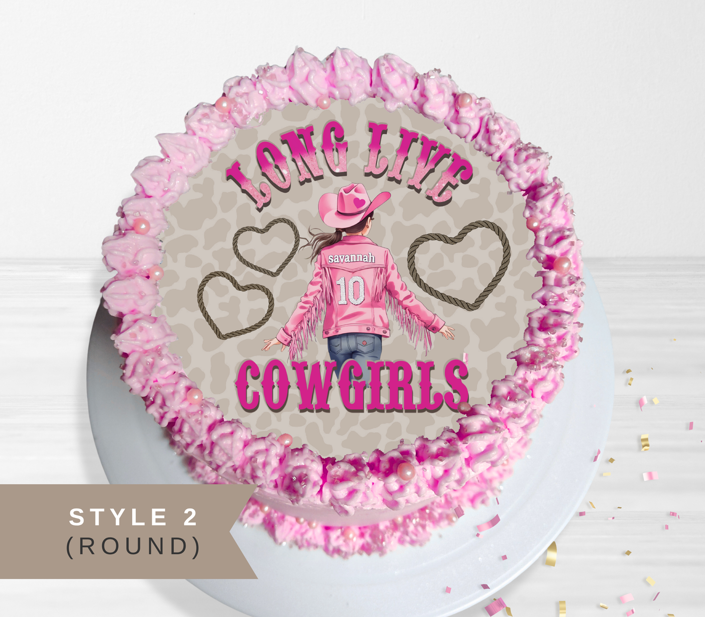 Round pink frosted cake topper or decoration featuring a cowboy girl illustration and the words 'LONG LIVE COWGIRLS' on a light gray background, shown on a white plate with a 'STYLE 2 (ROUND)' label overlay.