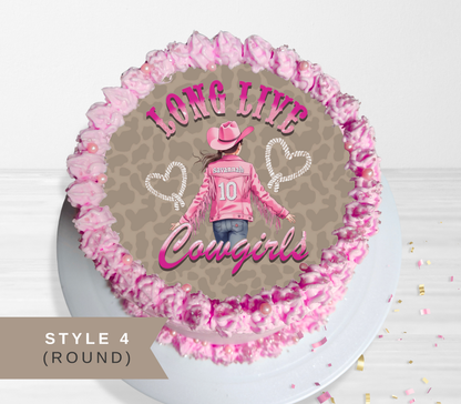 Round cake topper or cake decoration featuring a western cowgirl design with pink frosting piped around the edge, shown on a white plate against a light background. The design includes the words 'LONG LIVE Cowgirls' and a cowgirl illustration with a pink hat, pink jacket, jeans, and leopard-print background.